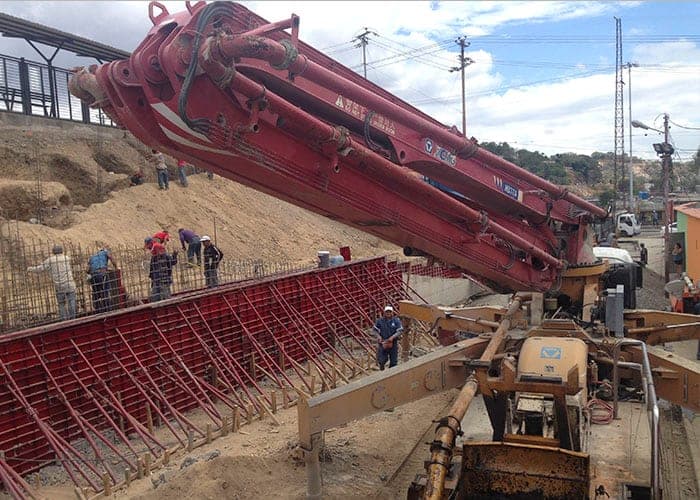 Bombeadora de pluma colocando concreto sobre el encofrado de un muro